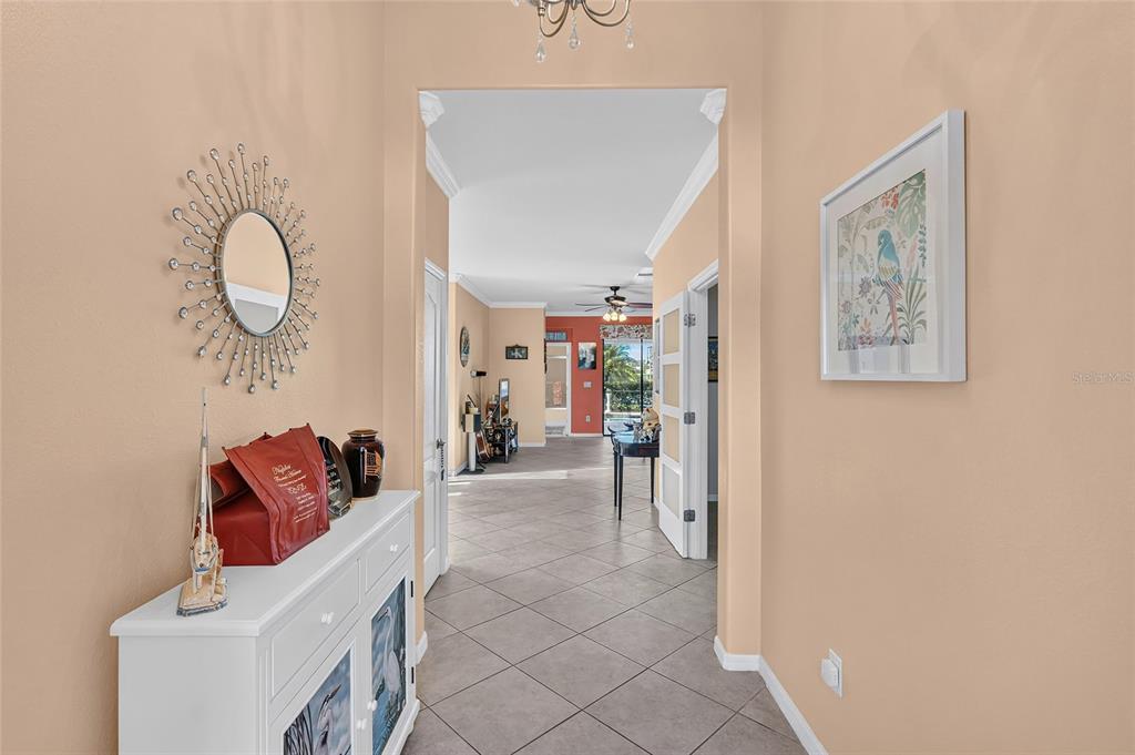 A tiled entryway leads into a living area with a white console table and mirror — 3652 TREASURE COVE CIRCLE, NAPLES, FL