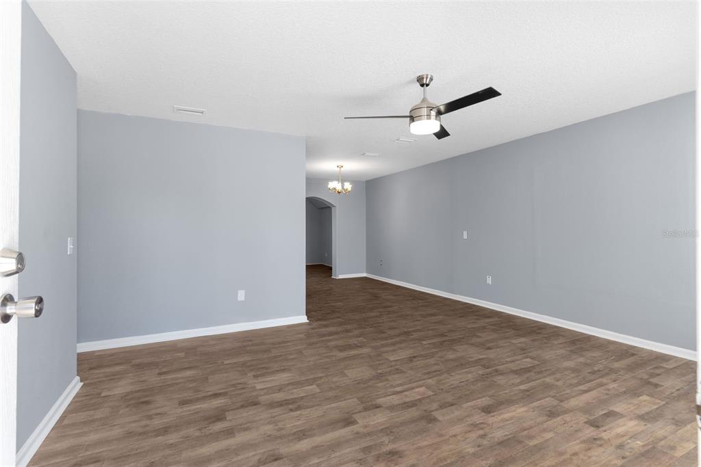An empty room with gray walls, wood-look flooring, and a ceiling fan — 16727 SE 91ST STREET, LAKE BUTLER, FL