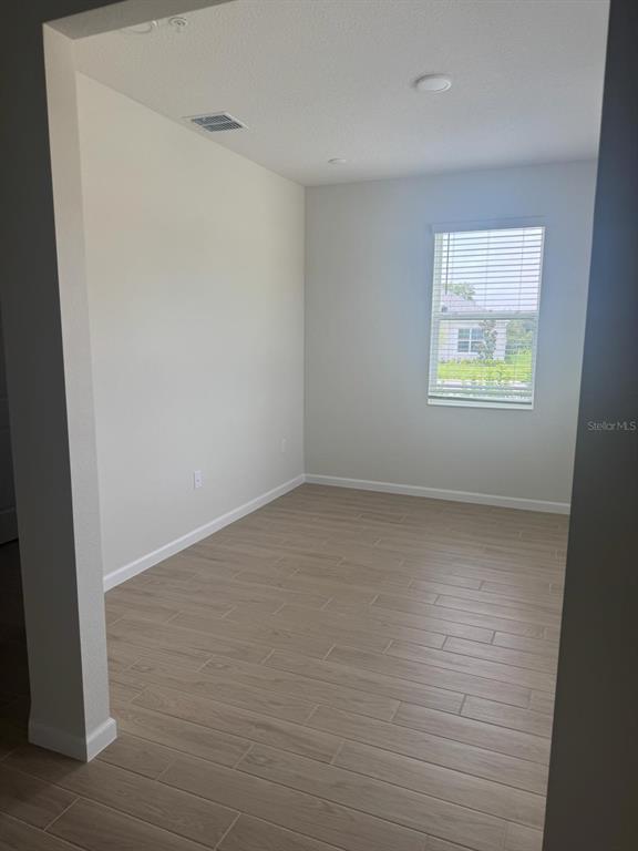 An empty room with light-colored walls, wood-look tile flooring, and a single window with blinds — 564 POTHOS STREET, APOPKA, FL