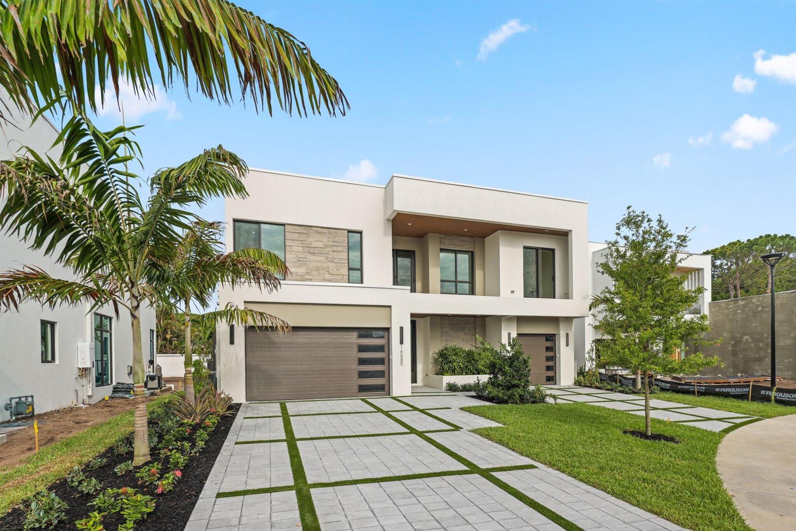 A modern two-story house features a paved driveway, a brown garage door, and stone accents — 16702 Mosaic Place, Delray Beach FL 33446, DELRAY BEACH, FL