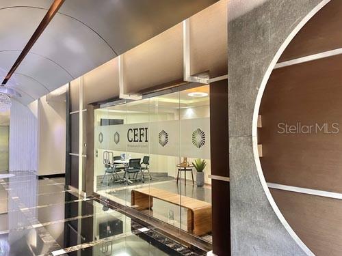A glass-walled office space features a wooden bench, modern furniture, and a polished floor — 650 MUÑOZ RIVERA, SAN JUAN, PR