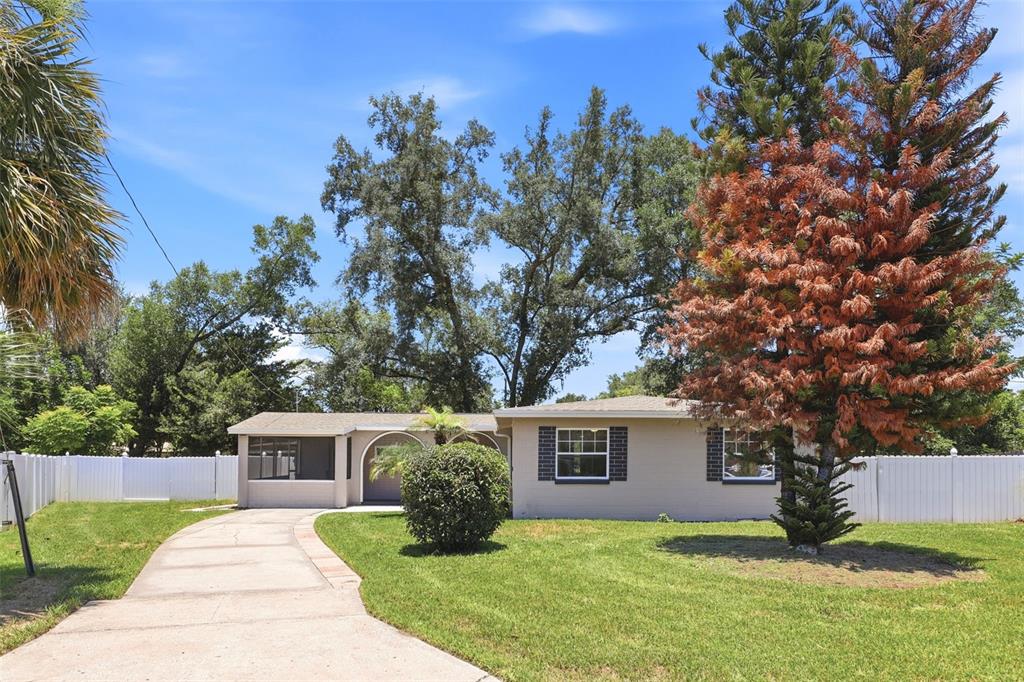 A single-story house with a beige exterior, a concrete driveway, and a large front lawn — 511 OXFORD COURT, ORLANDO, FL