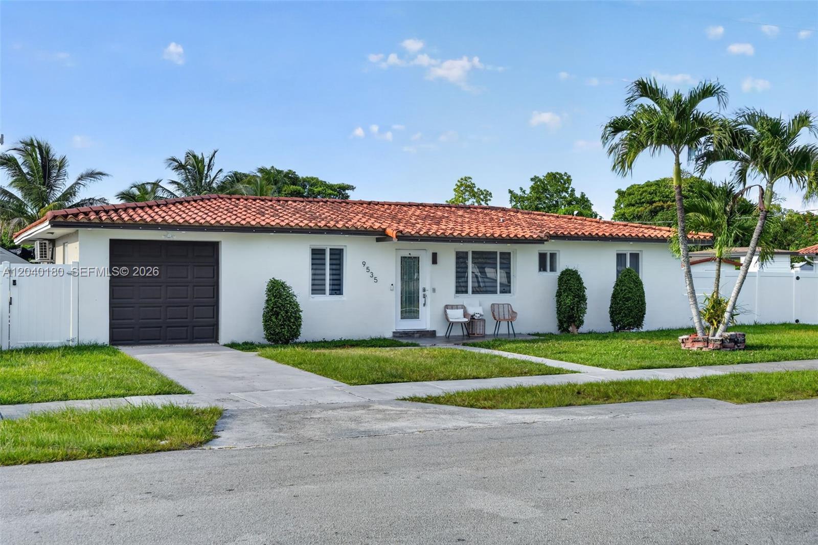 A single-story white house features a terracotta tile roof, a garage, and palm trees — 9535 SW 42nd St, Miami FL 33165, MIAMI, FL