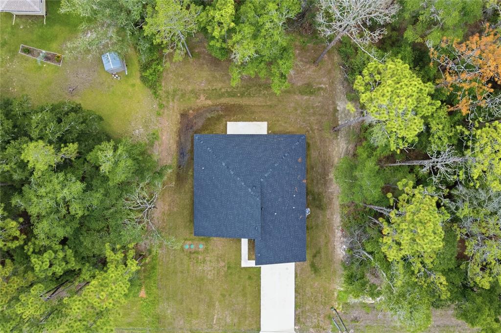 An aerial view shows a house with a dark roof, a driveway, and surrounding trees — 8809 N CIRCULAR WAY, CITRUS SPRINGS, FL