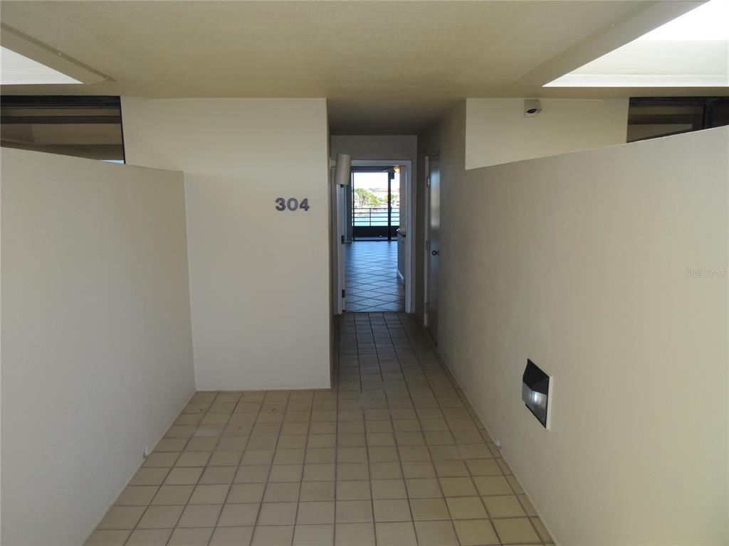 A tiled entryway leads to a doorway with a view of a balcony and water — 2775 KIPPS COLONY DRIVE S UNIT 304, ST PETERSBURG, FL