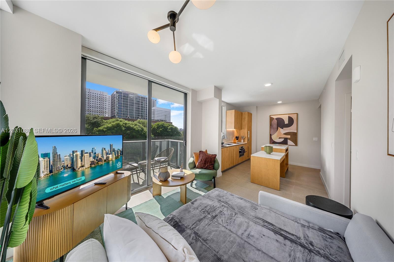 A modern studio apartment features a kitchen, living area, and a balcony with city views — 11 NE 6th St # 301, Miami FL 33132, MIAMI, FL