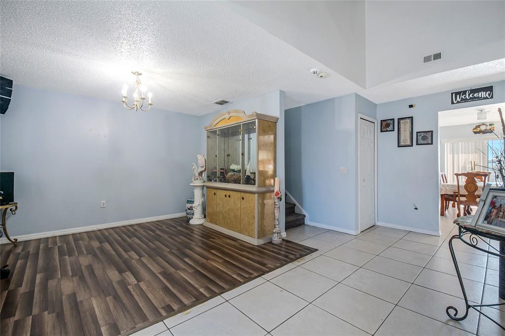 A room with light blue walls, wood-look flooring, tile flooring, and a large display cabinet — 6 ALICANTE COURT, KISSIMMEE, FL