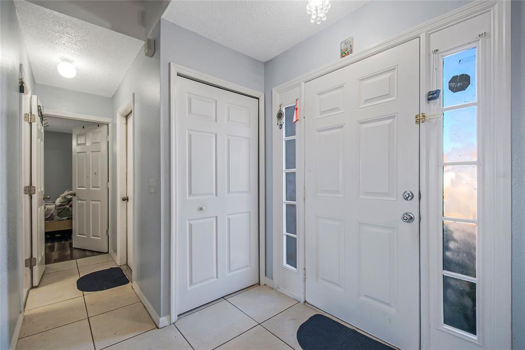 An entryway features white doors, light blue walls, and light-colored tile flooring — 6 ALICANTE COURT, KISSIMMEE, FL