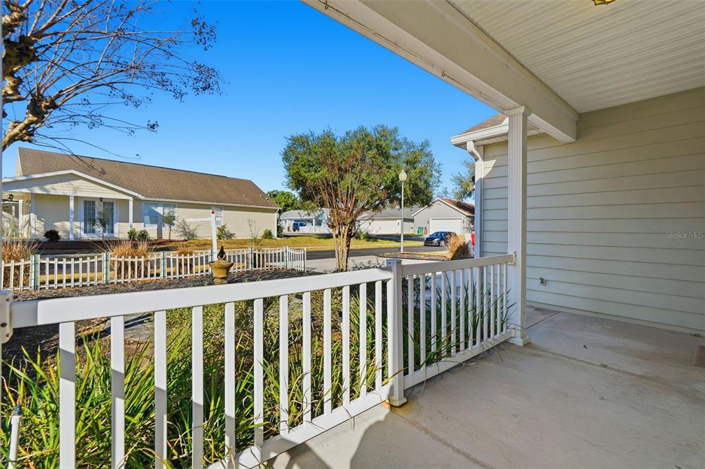 A view from a covered porch looking out toward a neighborhood street and houses — 37438 PICKETTS MILL AVENUE, ZEPHYRHILLS, FL