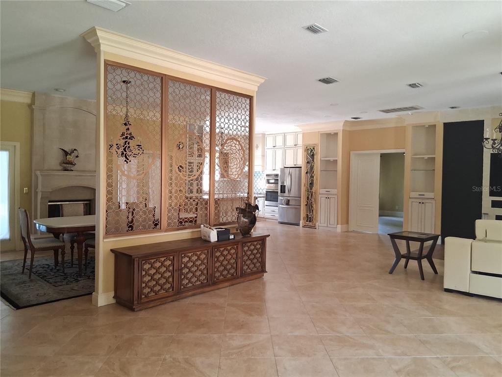 A spacious open-concept living area features a decorative lattice room divider and tile flooring — 915 OLD WELCOME ROAD, LITHIA, FL