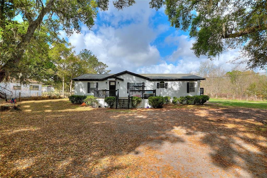 A single-story manufactured home with a metal roof and a front deck sits on a lot — 3309 COOPER ROAD, PLANT CITY, FL