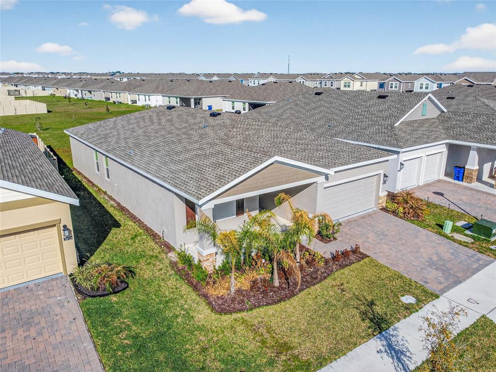 An aerial view of a suburban single-story house with a gray shingled roof and driveway — 2619 PEACE OF MIND AVENUE, KISSIMMEE, FL