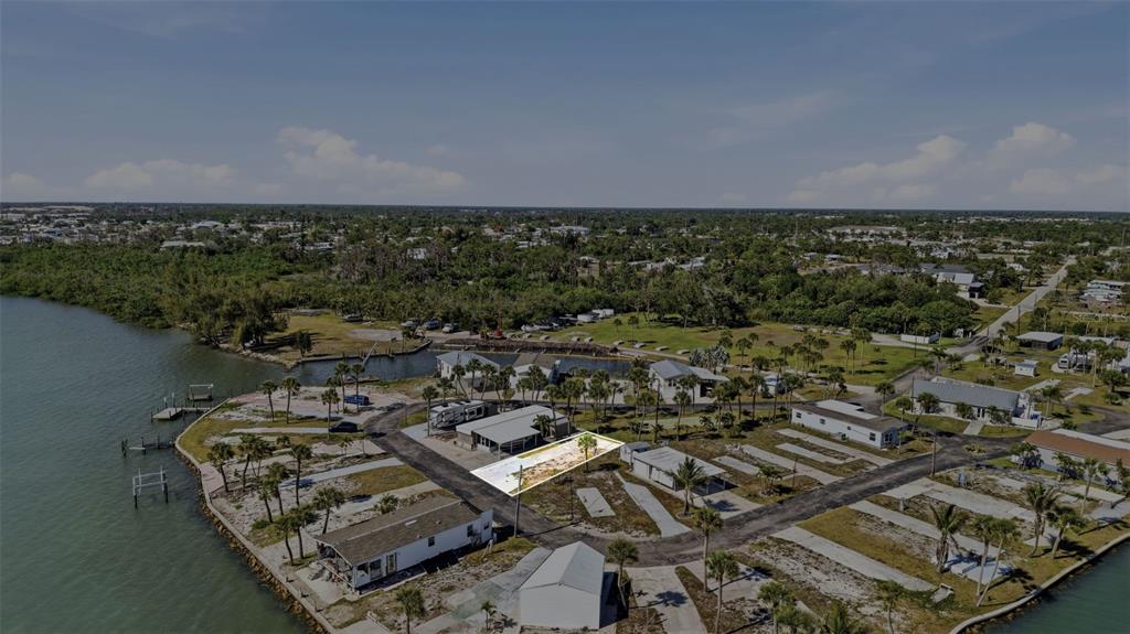 An aerial view shows a vacant, rectangular lot highlighted in a residential waterfront community — 7500 PARK POINTE DRIVE UNIT 49, ENGLEWOOD, FL