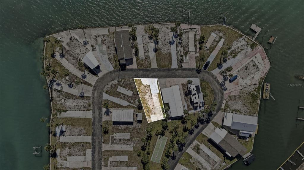 An aerial view shows a vacant, rectangular lot highlighted in white within a waterfront community — 7500 PARK POINTE DRIVE UNIT 49, ENGLEWOOD, FL