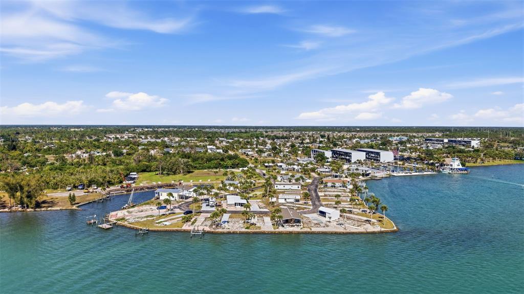 An aerial view shows a waterfront residential community with docks and palm trees — 7500 PARK POINTE DRIVE UNIT 49, ENGLEWOOD, FL