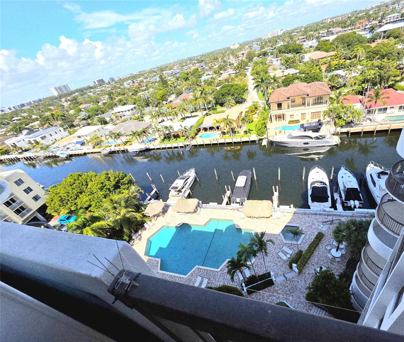 An elevated view of a canal with docked boats, a swimming pool, and surrounding homes — 1631 S Ocean Boulevard # 1006, Pompano Beach FL 33062, POMPANO BEACH, FL