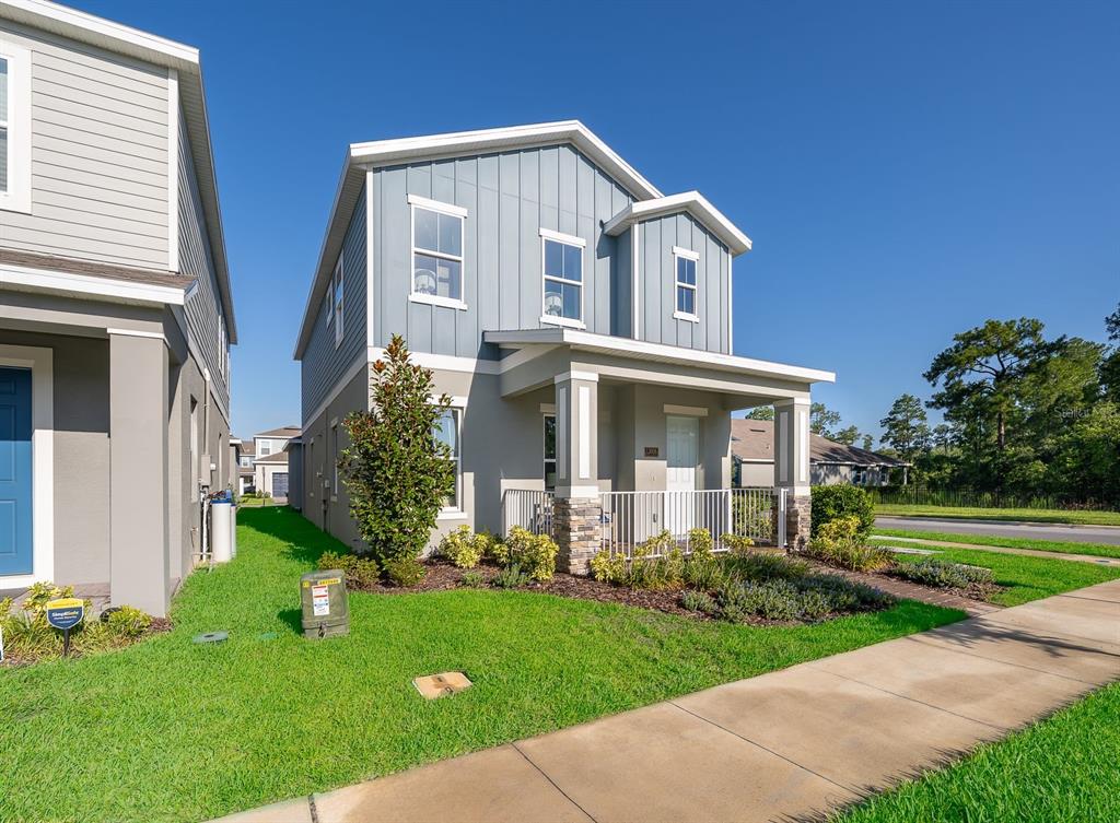 A two-story house with blue vertical siding and a front porch sits on a lawn — 13006 SERENE GLADE ROAD, WINTER GARDEN, FL
