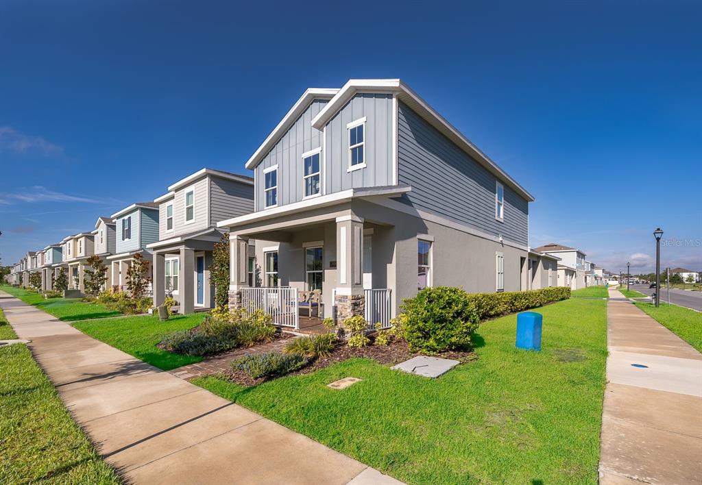 A row of two-story suburban houses with gray siding and front porches lines a sidewalk — 13006 SERENE GLADE ROAD, WINTER GARDEN, FL