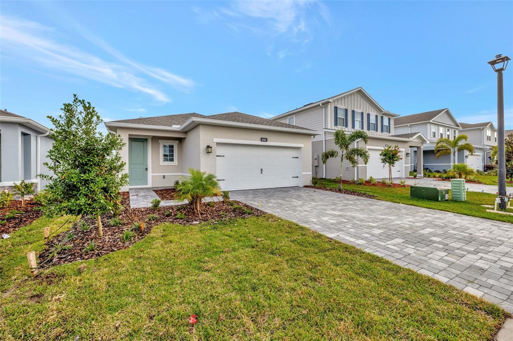 A single-story house with a white garage, light-colored siding, and a paved driveway — 4525 PIPPIN LANE, LAKEWOOD RANCH, FL
