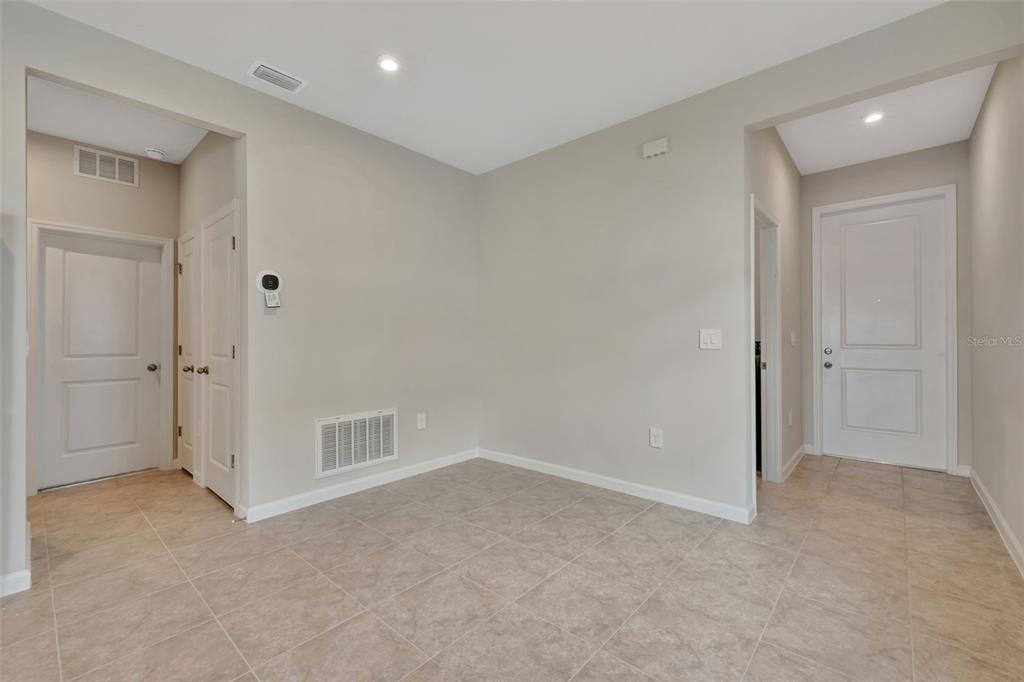 A neutral-toned room features tile flooring, recessed lighting, and several white interior doors — 4525 PIPPIN LANE, LAKEWOOD RANCH, FL