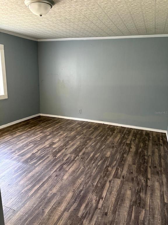 An empty room features gray walls, wood-look flooring, and a textured white ceiling — 110 VALENCIA STREET, WINTER HAVEN, FL