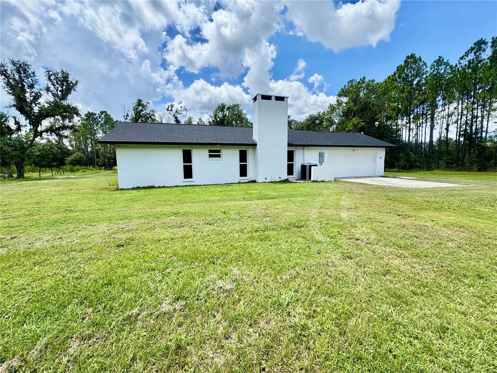 A white, single-story house with a prominent central chimney sits on a large grassy lot — 5812 N DORMANY ROAD, PLANT CITY, FL