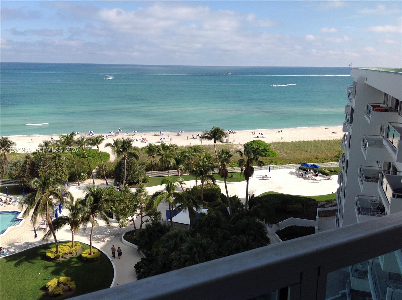 An elevated view of a beach, ocean, and resort grounds from a hotel balcony — 5151 Collins Ave # 1119, Miami Beach FL 33140, MIAMI BEACH, FL