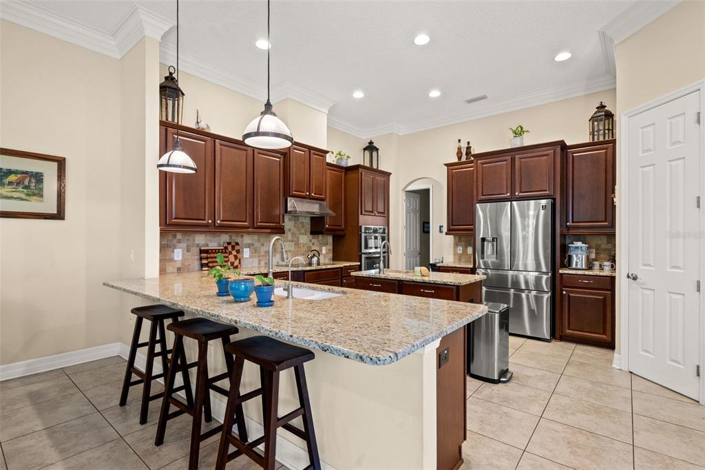 A dining room features a wooden hutch, an oval table with chairs, and a chandelier — 15103 AZRA DRIVE, ODESSA, FL