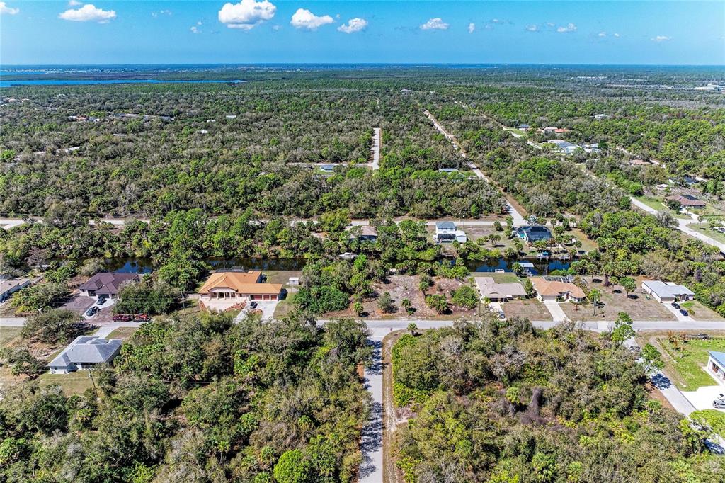 An aerial view shows houses scattered among dense trees and a canal in Florida — 3067 COMO STREET, PORT CHARLOTTE, FL
