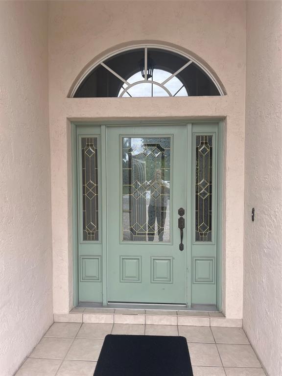 A sage green front door with glass panels and a semi-circular transom window — 174 GRAND OAK CIRCLE, VENICE, FL