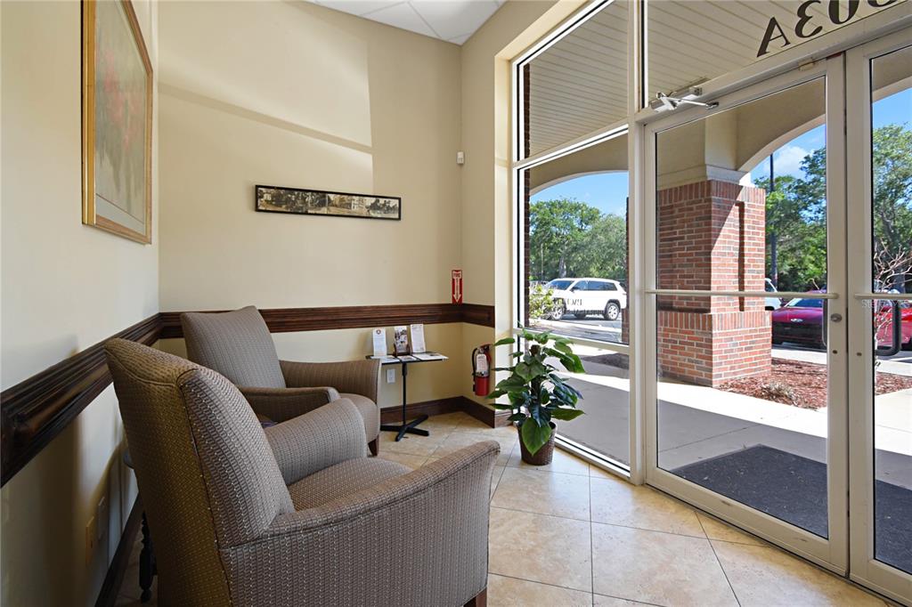 A waiting area features two armchairs, a small side table, and a glass-paned entrance door — 1301 PLANTATION ISLAND DRIVE S UNIT 303A, ST AUGUSTINE, FL