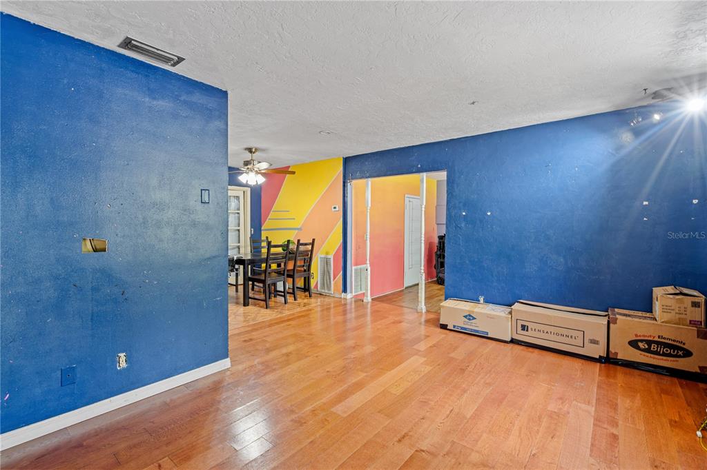 A room with blue walls, hardwood floors, and a dining area with colorful wall murals — 1717 NE 28TH AVENUE, GAINESVILLE, FL