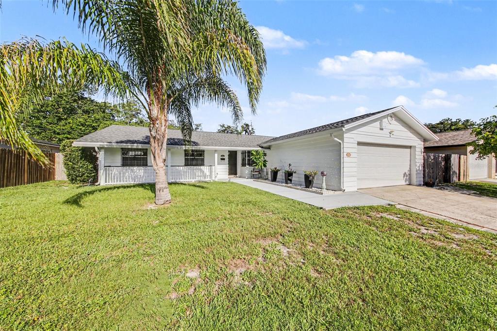A white single-story house with a front porch, a palm tree, and a two-car garage — 2511 EASTBROOK BOULEVARD, WINTER PARK, FL