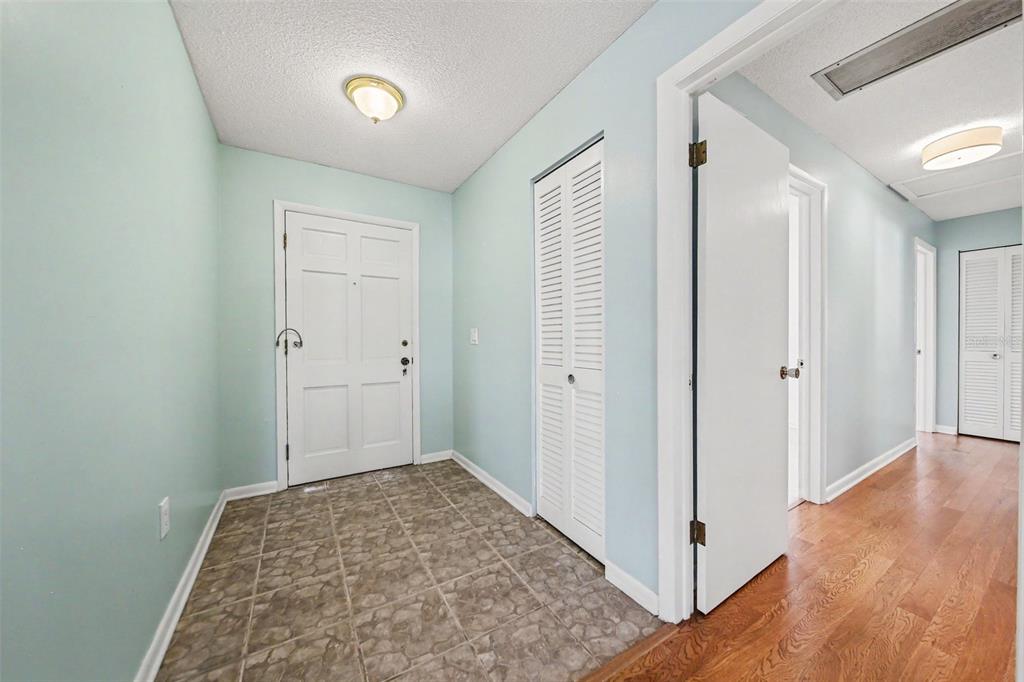 An entryway with light blue walls, tile flooring, and a white louvered closet door — 2511 EASTBROOK BOULEVARD, WINTER PARK, FL