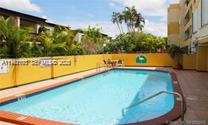 An outdoor swimming pool with a metal handrail sits in front of a yellow wall — 8320 NW 8th St # 110, Miami FL 33126, MIAMI, FL