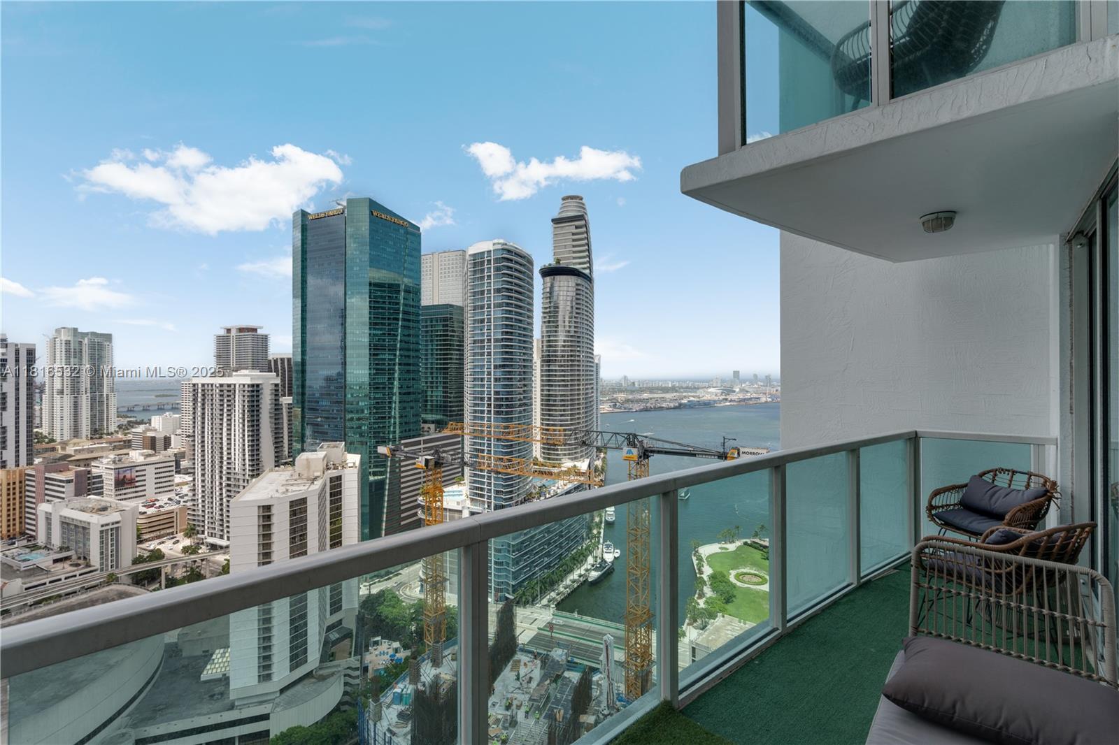 A high-rise balcony overlooks a city skyline, a river, and construction cranes — 41 SE 5th St # 2107, Miami FL 33131, MIAMI, FL