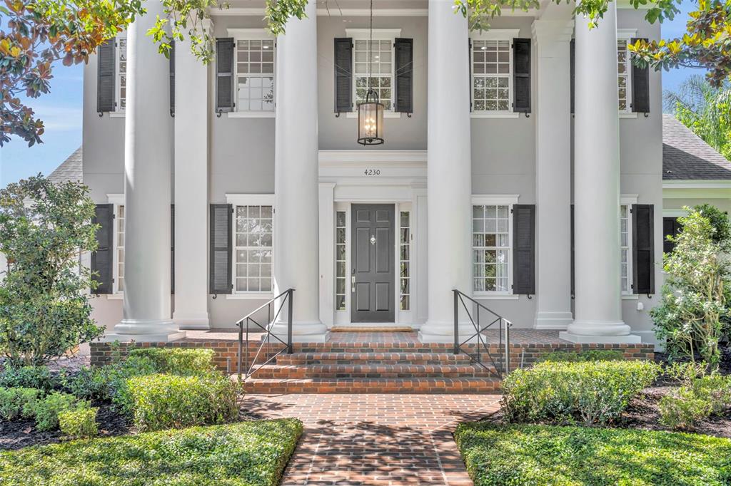 The exterior of a two-story house features large white columns and a brick walkway — 4230 LOWER PARK ROAD, ORLANDO, FL