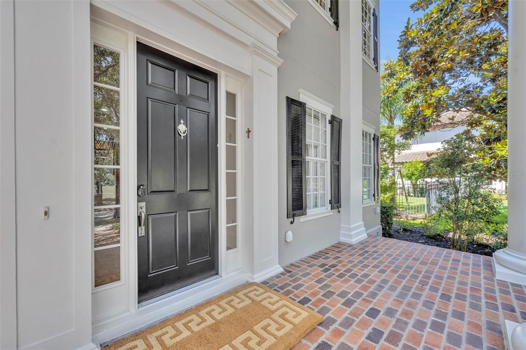 A black front door with a knocker sits on a brick porch with white columns — 4230 LOWER PARK ROAD, ORLANDO, FL