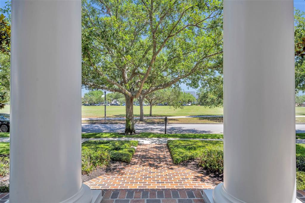 A view from a porch with two white columns looking out toward a grassy park — 4230 LOWER PARK ROAD, ORLANDO, FL