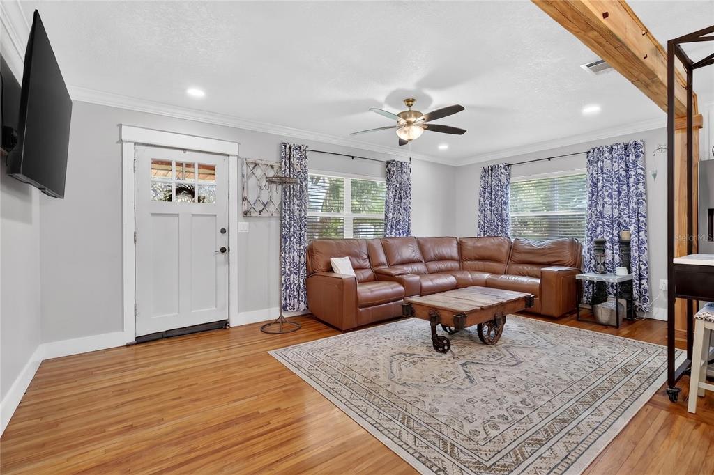 A living room features a brown leather sectional, a wooden coffee table, and hardwood floors — 1570 IMPERIAL AVENUE, BARTOW, FL