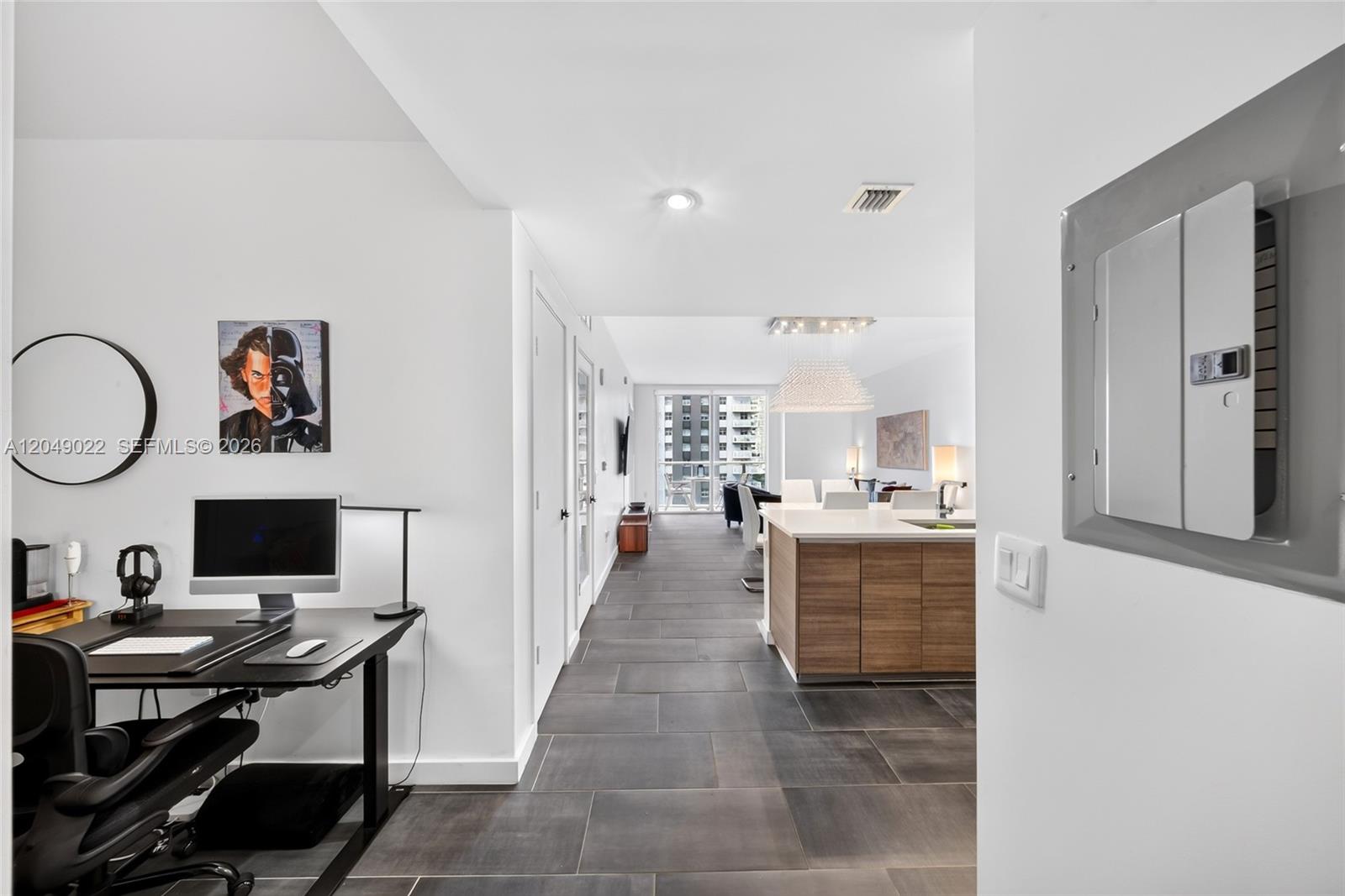 A home office area leads into an open-concept kitchen and living space with tile flooring — 1100 S Miami Ave # 1603, Miami FL 33130, MIAMI, FL