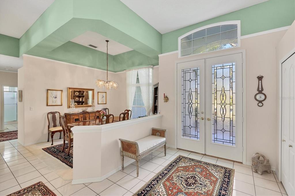 A foyer with a tile floor and a dining area featuring a tray ceiling — 8684 WOODBRIAR DRIVE, SARASOTA, FL