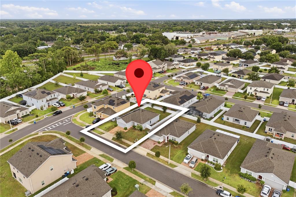 An aerial view shows a single-story house with a fenced backyard in a suburban neighborhood — 541 WILDCAT LANE, DAVENPORT, FL