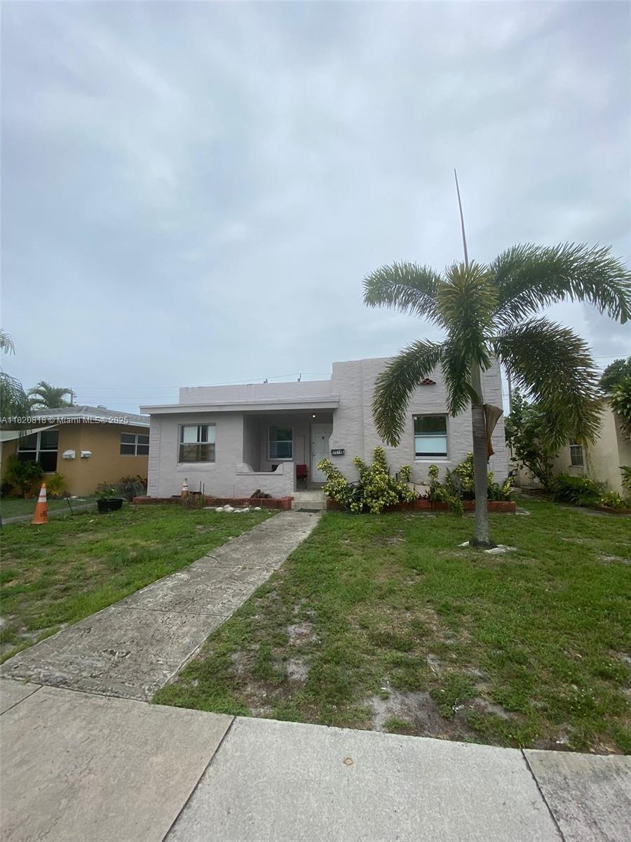 A single-story stucco house features a front porch, a palm tree, and a concrete walkway — 2014 Funston St, Hollywood FL 33020, HOLLYWOOD, FL