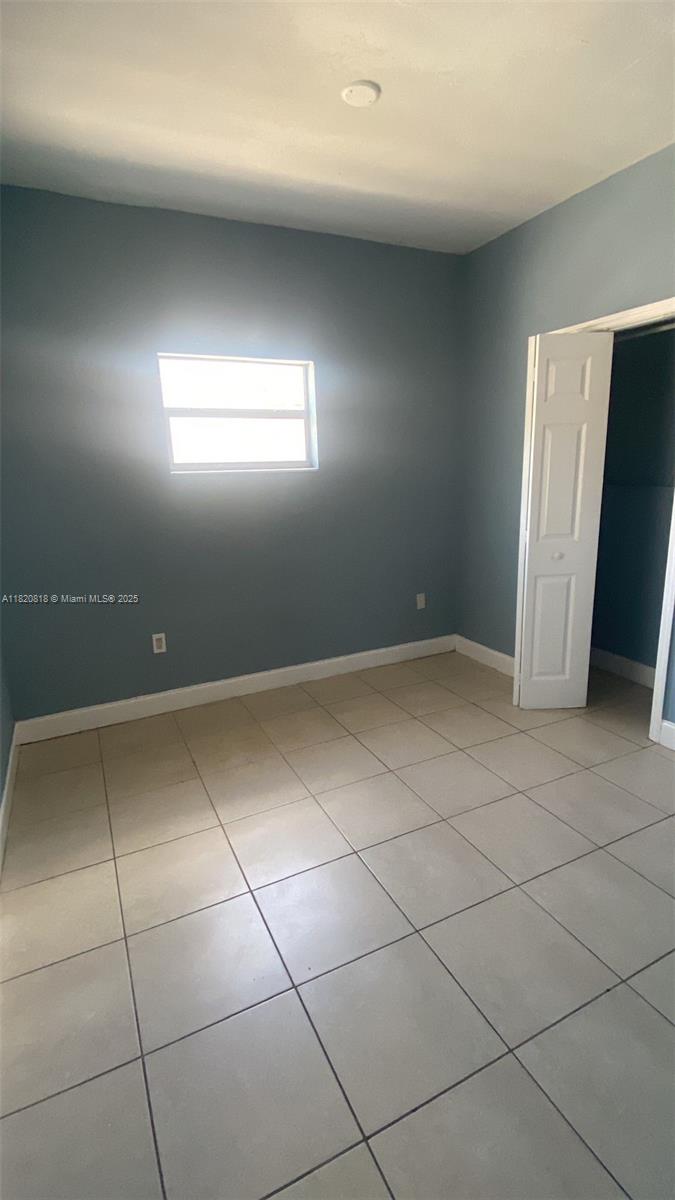 This room features light blue walls, a window, and light-colored square floor tiles — 2014 Funston St, Hollywood FL 33020, HOLLYWOOD, FL