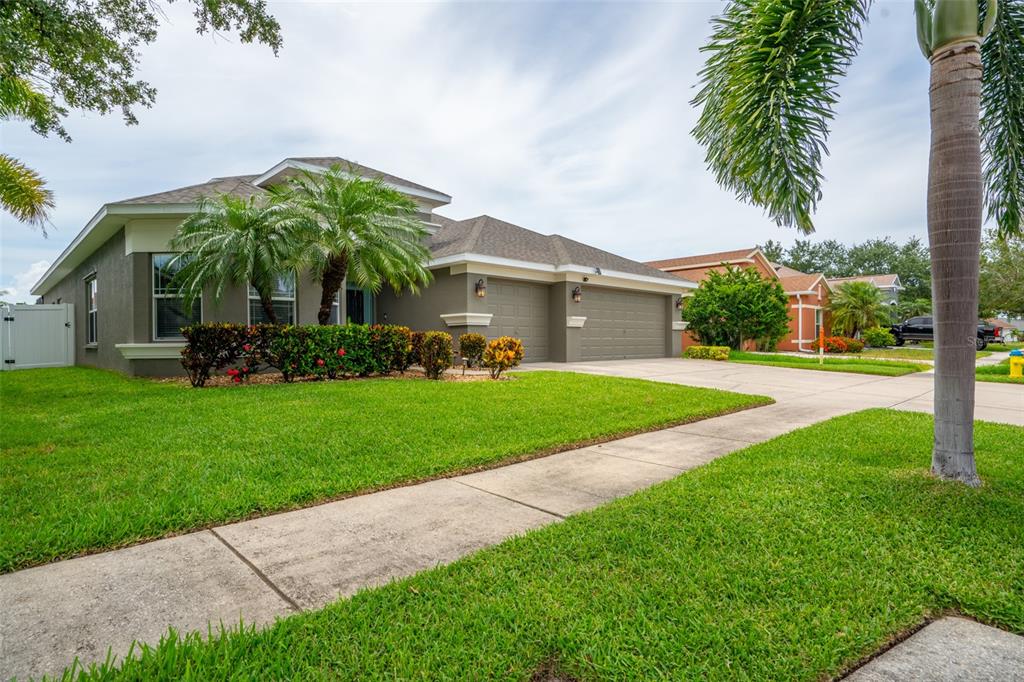 A single-story house with a gray exterior, a two-car garage, and a manicured front lawn — 1809 BONITA BLUFF COURT, RUSKIN, FL