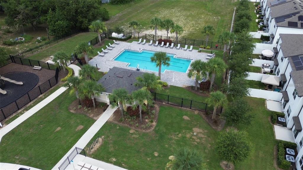 An aerial view shows a community swimming pool, a clubhouse, and a playground — 645 MADISON DRIVE, DAVENPORT, FL