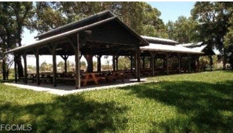 A large, open-air wooden pavilion with picnic tables sits on a grassy lawn — 16791 SAN EDMUNDO ROAD, PUNTA GORDA, FL