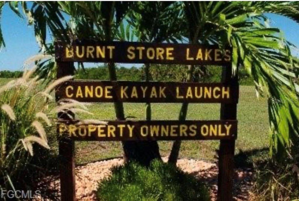 A wooden sign reads Burnt Store Lakes Canoe Kayak Launch Property Owners Only — 16791 SAN EDMUNDO ROAD, PUNTA GORDA, FL