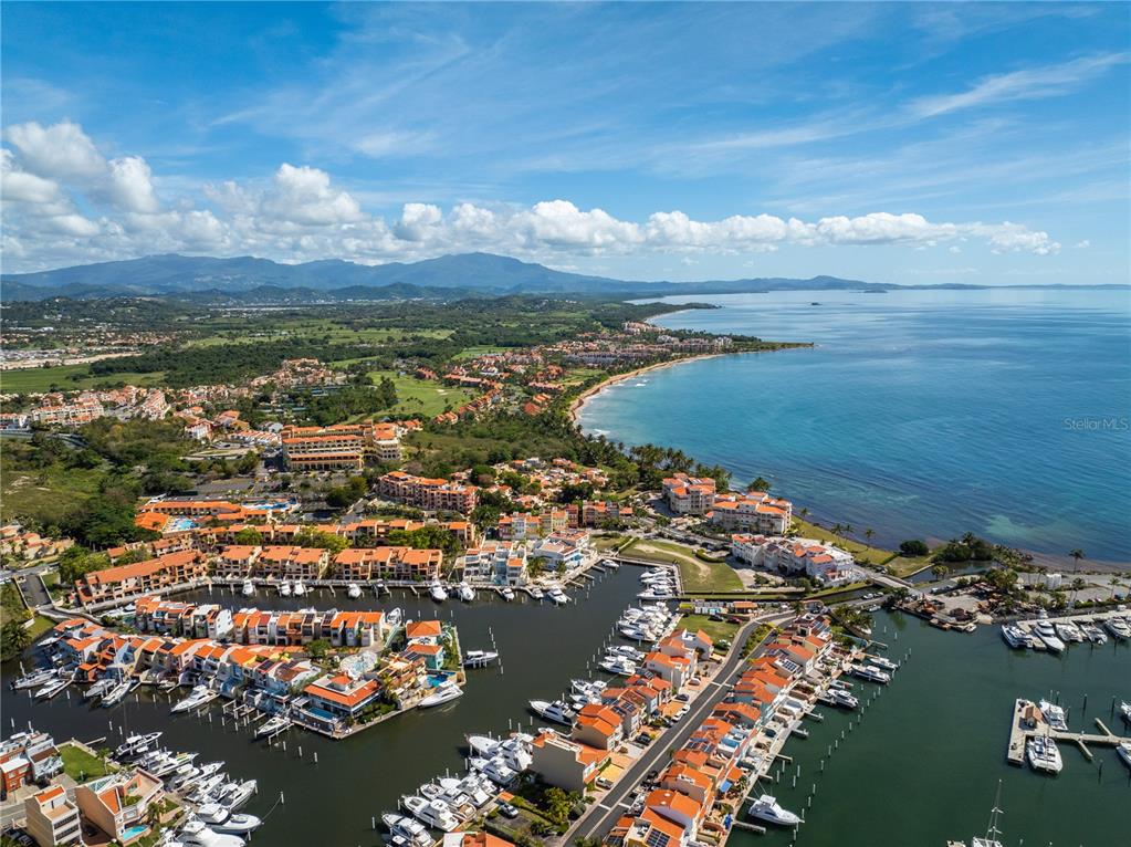 An aerial view shows a coastal marina with numerous boats docked beside residential buildings — 295 Palmas Inn Way E PALMAS INN WAY PALMANOVA PLAZA UNIT 112,113,114, HUMACAO, PR